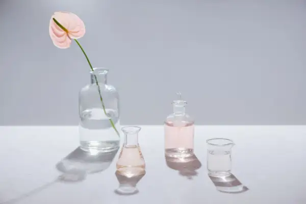 Różowa anturium w wazonie i szklane naczynia z płynami. Czy benzyl alcohol czy jest szkodliwy?