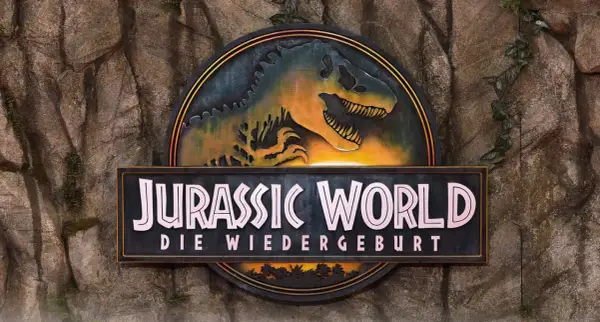 Das Logo von Jurassic World: Die Wiedergeburt, mit einem T-Rex-Kopf, bereit für den Jurassic World Stream.
