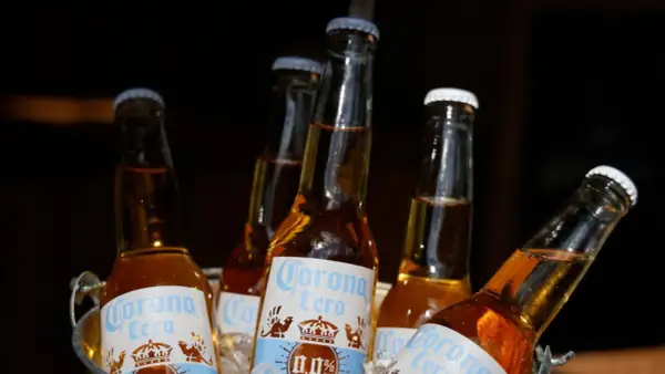 Kilka butelek piwa Corona Cero w wiaderku z lodem. Idealne na upalny dzień, to piwo na c jest orzeźwiające i bezalkoholowe.