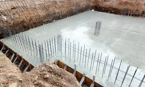 Budowa fundamentów: świeży beton i zbrojenie zapowiadają prawidłową izolację fundamentów.