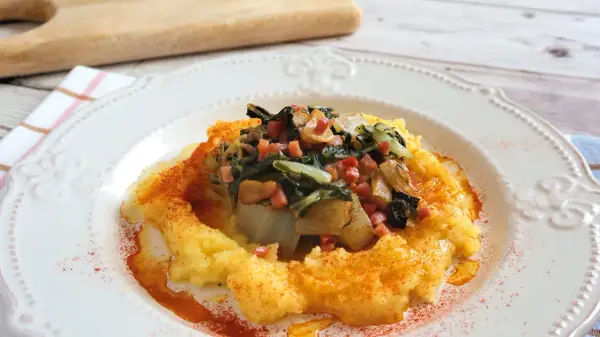 Puré de patatas con un sofrito de acelgas y trocitos de jamón. Una deliciosa receta con acelgas, espolvoreada con pimentón.