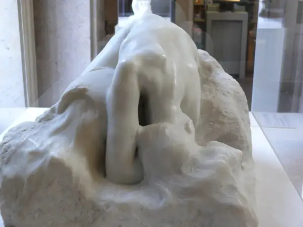 Kamienna postać pochylona w głębokiej zadumie, jak Auguste Rodin Myśliciel, wpatruje się w otchłań własnych myśli.