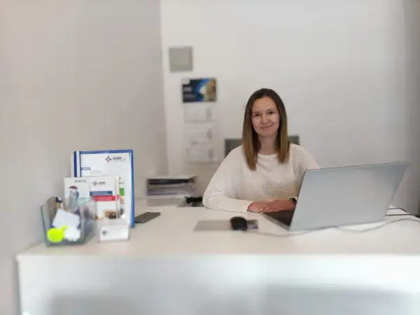 Kobieta przy biurku z laptopem i dokumentami.