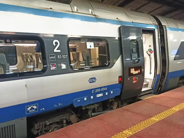 Pociąg Pendolino z otwartymi drzwiami, widoczne siedzenia i numer wagonu 2. Idealny czas na zniżki na pendolino!