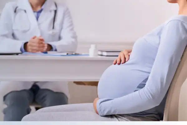 Mujer embarazada consulta a su médico por dolor de ovarios.