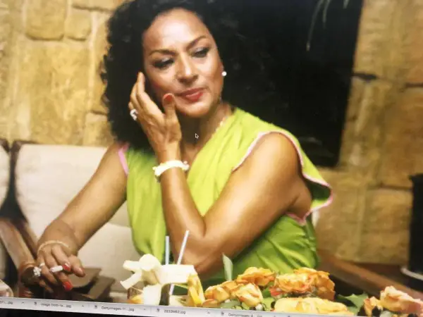 Lola Flores, icónica artista, sonríe con un cigarrillo en la mano. Su fecha de nacimiento es un misterio para muchos, pero su legado es eterno.