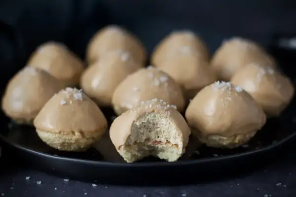 Små, karamellglaserade biskvier med flingsalt, ett läckert biskvier recept. En är uppäten och visar det fluffiga inkråmet.