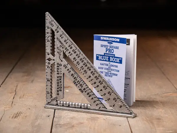 A Swanson Speed Square and its "Blue Book" guide, showing how to use a speed square for roof construction.