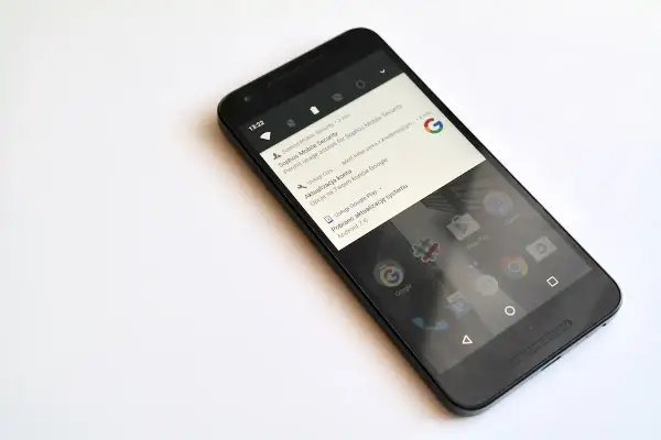 Czarny smartfon z powiadomieniem o pobraniu aktualizacji systemu Android 7.0 Nougat.