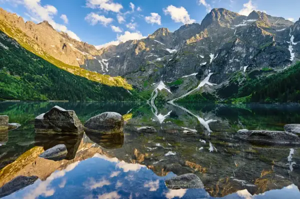 Tatry latem: Morskie Oko odbija skaliste szczyty i zielone zbocza. Idealne miejsce na wakacje, by odkryć bukowina tatrzańska atrakcje.