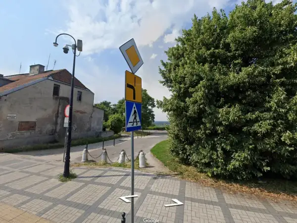 Znak pierwszeństwo łamane kierunkowskaz informuje o skręcie w prawo i ustąpieniu pierwszeństwa. Obok znak przejścia dla pieszych.