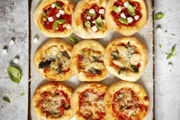 Gotowe ciasto na pizzę w różnych wariantach: z fetą i bazylią, z karczochami i szpinakiem, oraz z warzywami.