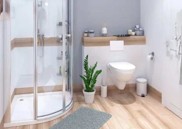 Moderne badezimmer ideen: Duschkabine, Toilette, Pflanze und Holzboden schaffen eine einladende Atmosphäre.
