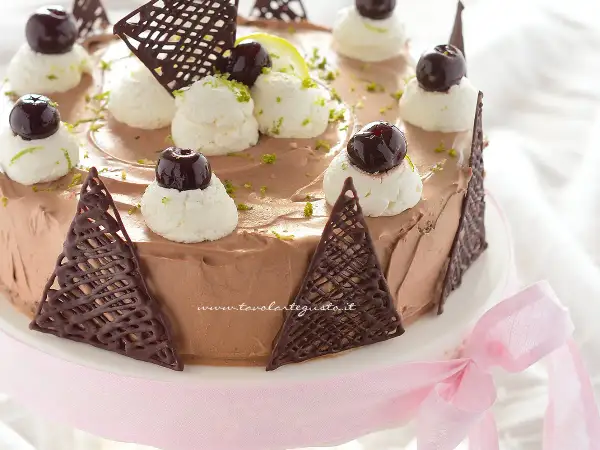 Deliziosa torta **foresta nera dolce** con panna montata, ciliegie e decorazioni di cioccolato.