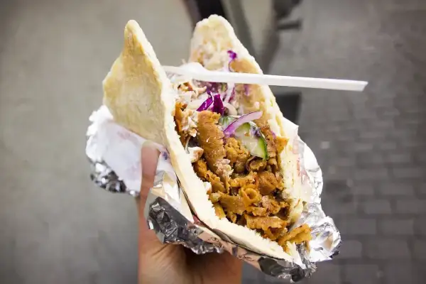 Pyszny kebab co to? Mięso, warzywa i sos w bułce, zawinięte w folię. Idealny na szybki posiłek.