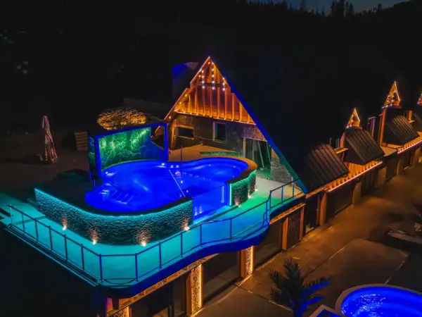Nocny aquapark Stegna z podświetlanym basenem i architekturą góralską.