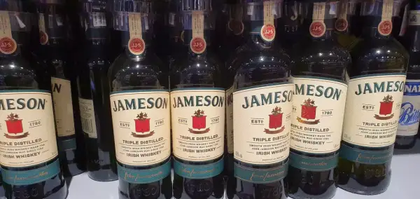 Rząd butelek Jameson Triple Distilled Irish Whiskey. Idealne na prezent lub do domowego barku, to dobre whisky z Biedronki.