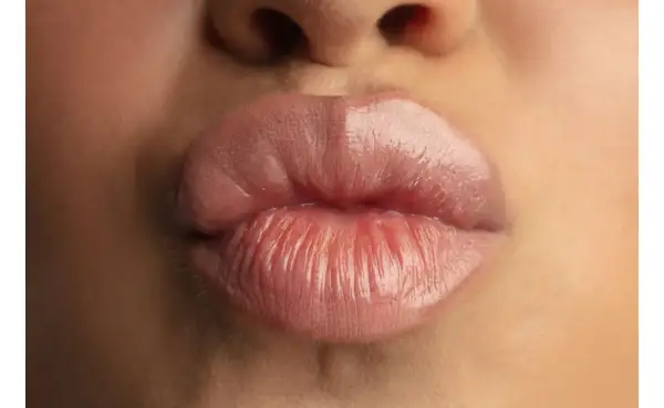 Labbra carnose e lucide, un primo piano che mostra come rimpolpare le labbra per un effetto voluminoso e sensuale.