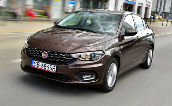Brązowy fiat tipo sedan w ruchu miejskim.