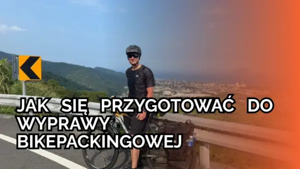 Mężczyzna z rowerem na górskiej drodze, przygotowuje się do wyprawy bikepackingowej. Informacje o rowerze i trasie.