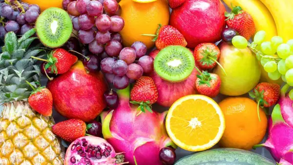 Un assortiment coloré de fruits frais : ananas, fraises, raisins, kiwis, pommes, oranges, bananes, poires, fruits du dragon et grenades. Une excellente source de fibre pour une alimentation saine.