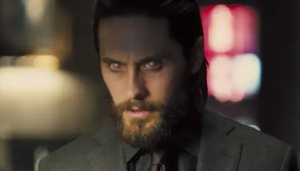 Jared Leto w filmach, z bladymi oczami i brodą, w garniturze.