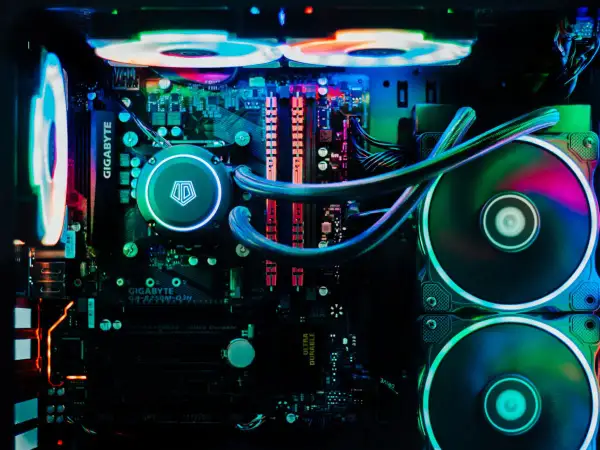 Wnętrze komputera z podświetleniem RGB. Widoczny system chłodzenia wodnego i wentylatory, które zapewniają efektywne chłodzenie.