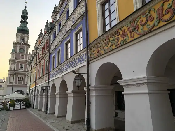 Zamość co zobaczyć: kolorowe kamienice z arkadami i wieża ratuszowa tworzą malowniczy widok.