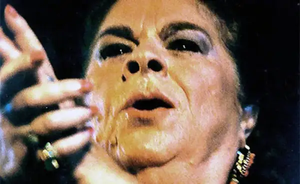 Primer plano de una mujer con maquillaje dramático, labios entreabiertos y mano levantada. Se especula de que murió la Paquera de Jerez.