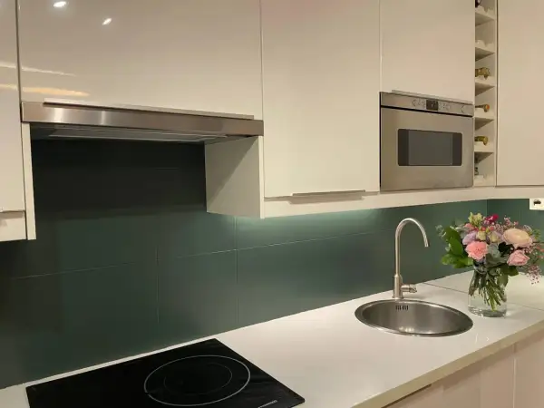 Crédence cuisine vert foncé, une idée pour quelle peinture pour carrelage mural cuisine ? Évier, hotte, four, bouquet de fleurs.