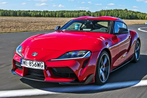 Czerwona Toyota Supra pędzi po torze. Zastanawiasz się, ile kosztuje Toyota Supra? Ten sportowy samochód robi wrażenie!