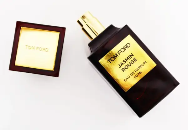 Elegancka butelka perfum Tom Ford Jasmin Rouge z złotą etykietą i korkiem.