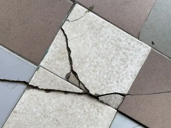 Un carreau de carrelage est brisé, montrant la nécessité de le changer.