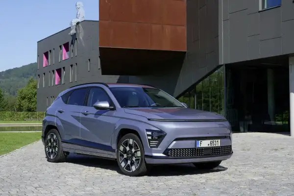 Le plus petit SUV, un véhicule gris moderne, se gare devant un bâtiment architectural audacieux.