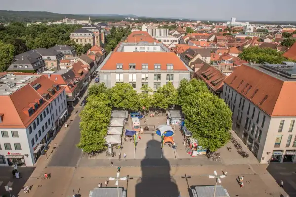 Marktplatz in Erlangen mit Ständen und Bäumen. Ein Schatten wirft sich über den Platz, vielleicht ein Geheimtipp für Fotografen.