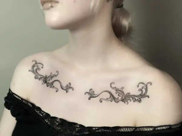 Delikatny tatuaż ornament damski na obojczykach, przypominający koronkę.