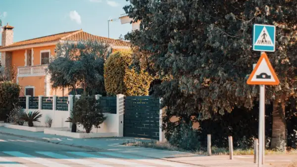 Panneau de passage piétons et ralentisseur. La question "un particulier peut-il filmer la voie publique" se pose devant cette maison.