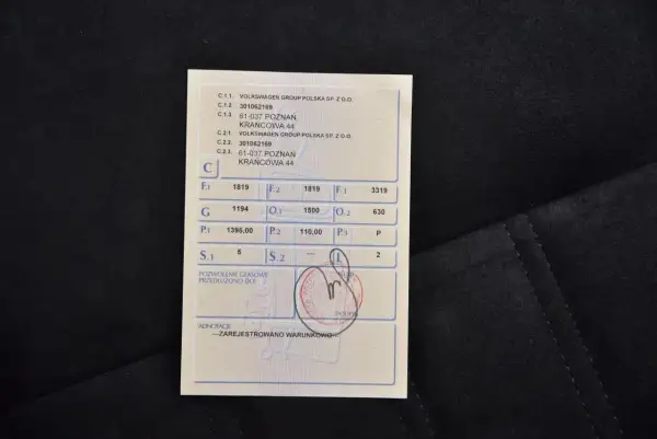 Dokument z danymi pojazdu, zawiera m.in. informacje o właścicielu i numerze VIN. Widoczny jest również tymczasowy dowód rejestracyjny.