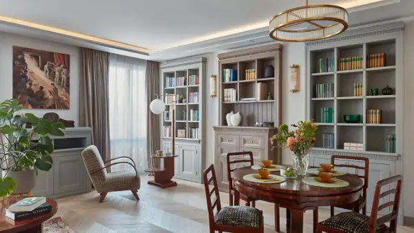 Elegancki salon z biblioteczkami, jadalnią i wygodnym fotelem. Klasyczny styl dekoracji wnętrz.