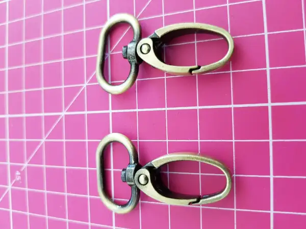 Dos mosquetones de latón envejecido, perfectos para tu mochila o llavero.