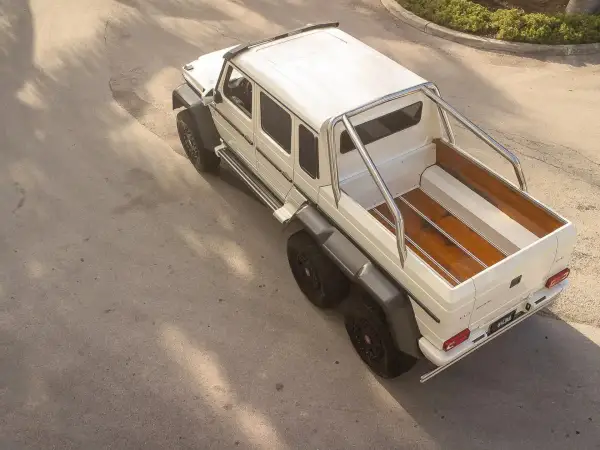Biały Mercedes 6x6 z drewnianą paką, gotowy na każdą przygodę.