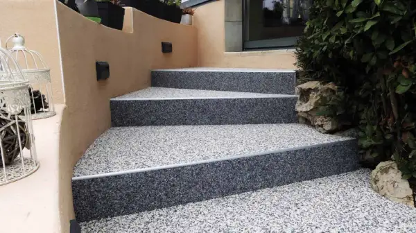 Escalier extérieur avec un revêtement moderne en granulats pour un style unique.