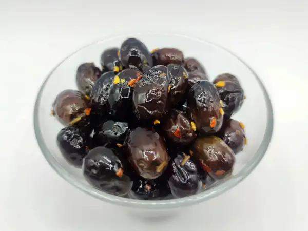 Olive nere sotto sale, un classico della ricetta marchigiana, in una ciotola di vetro.