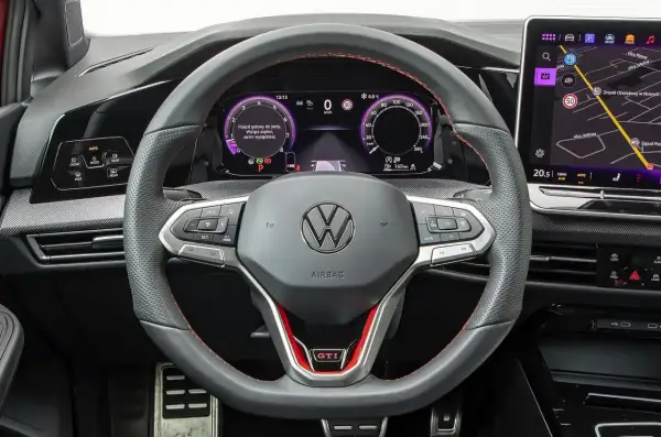 Kierownica VW z cyfrowymi zegarami i nawigacją. Zastanawiasz się, ile kosztuje obszycie kierownicy? Ten model ma sportowe akcenty GTI.