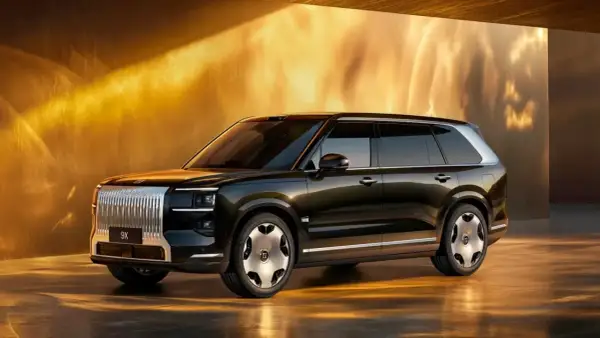 Elegancki, ciemny SUV Zeekr 9X z chromowanym grillem i futurystycznymi felgami, prezentowany w złotym, oświetlonym wnętrzu.