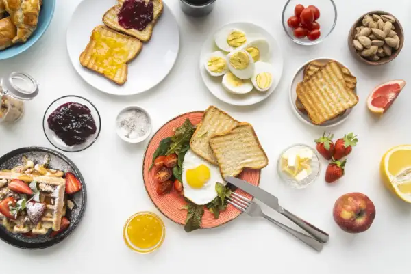 Un uovo al tegamino con pomodorini e toast, waffle con fragole, uova sode, frutta e marmellata: una colazione salata sana e gustosa.