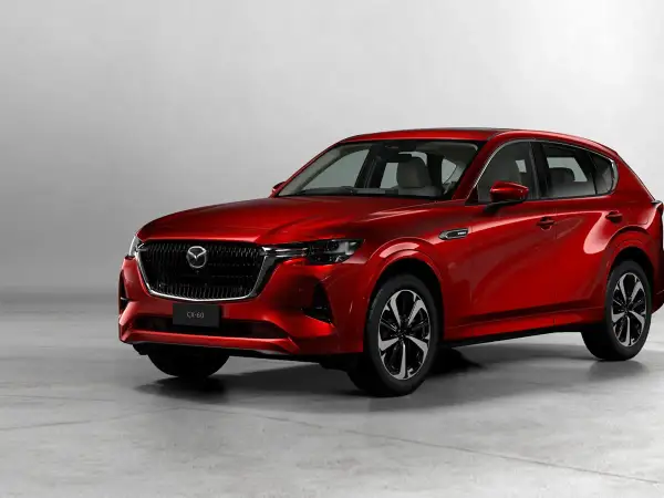 Elegancka, czerwona Mazda CX-60 3.3 Diesel prezentuje swoje dynamiczne linie na tle jasnego studia.