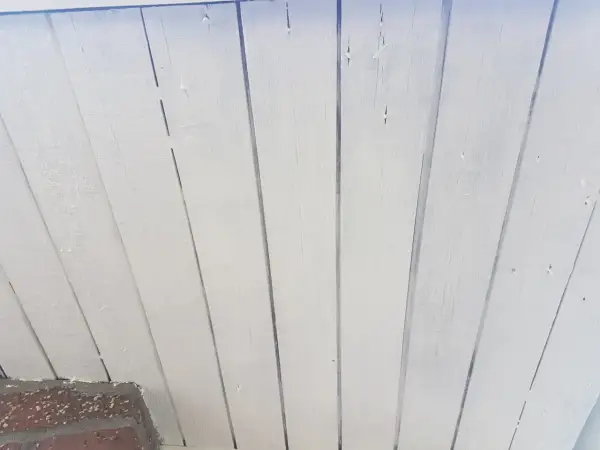Vitmålad träpanel som takfot, redo för ett nytt lager färg.