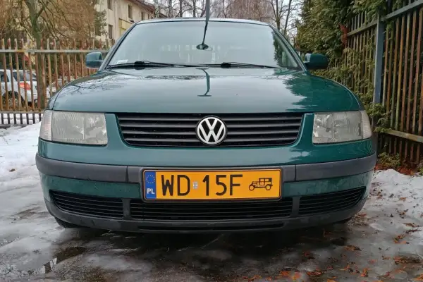 Zielony samochód zabytkowy, może 25 czy 30 lat, z charakterystycznym znaczkiem VW na grillu, stoi na oblodzonym podjeździe.