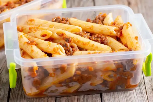Penne z sosem bolońskim w pojemniku. Czy ugotowany makaron można zamrozić? Tak, to świetny sposób na przechowywanie posiłków.